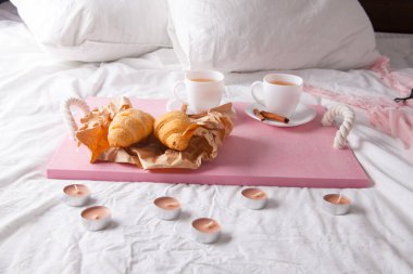 Kahvaltı tablada meyve ve hamur işleriyle birlikte. Waffle, kruvasan, kahve ve meyve suyu.