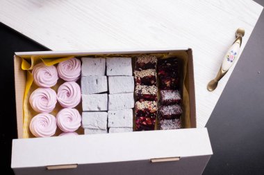 Kağıt ambalajda marşmelov. Gül şeklinde bir Zephyr. Siyah arkaplanda.