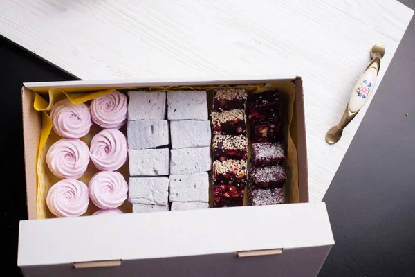 Kağıt ambalajda marşmelov. Gül şeklinde bir Zephyr. Siyah arkaplanda.