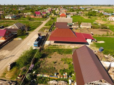 Bir gölgelik avlu üzerinde olan bir ev. Oluklu metal profil çatıdan. Metal kiremit