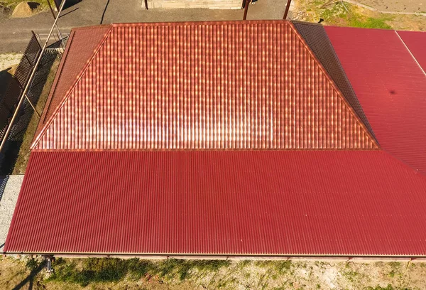 Bir gölgelik avlu üzerinde olan bir ev. Oluklu metal profil çatıdan. Metal kiremit