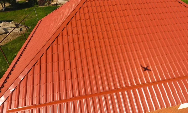 トップ ビューで作られたオレンジ色の屋根の家 屋根の上に段ボールを描いた金属プロファイル — ストック写真