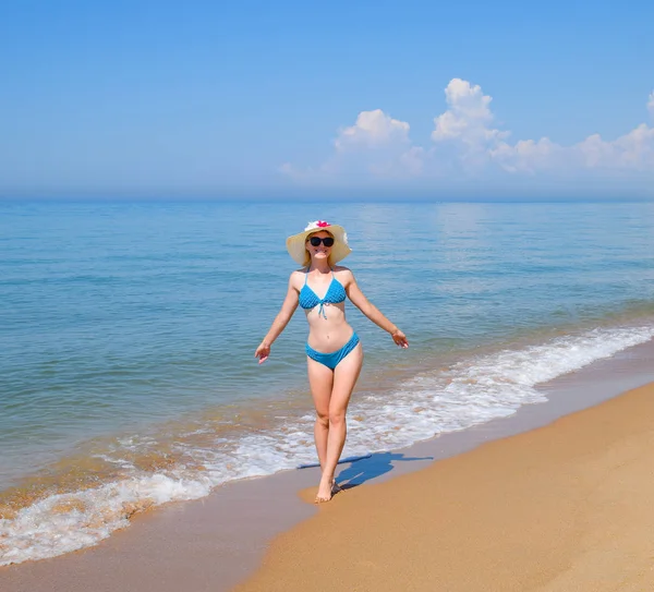 穿着蓝色泳装的金发女郎和沙滩上的白帽子 美丽的海滨海滩 — 图库照片