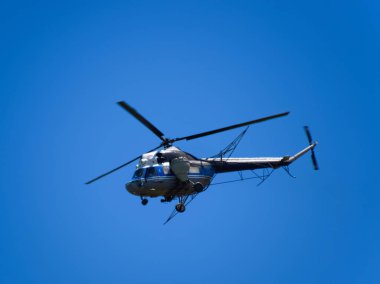 Bir helikopter tarımsal Havacılık mavi gökyüzünde uçuyor. Gübre ve tarım ilaçları püskürtme için helikopter
