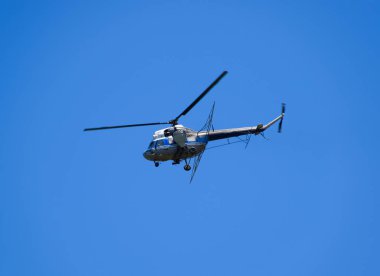 Bir helikopter tarımsal Havacılık mavi gökyüzünde uçuyor. Gübre ve tarım ilaçları püskürtme için helikopter