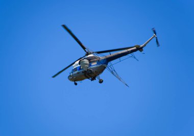 Bir helikopter tarımsal Havacılık mavi gökyüzünde uçuyor. Gübre ve tarım ilaçları püskürtme için helikopter