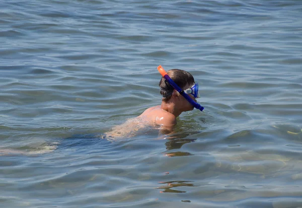 Il tipo sta nuotando con una maschera e un tubo nel mare — Foto Stock