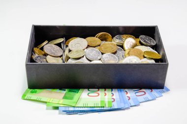 Bir kumbara kutusunda farklı mezhepleri sikkeleri. Kumbara altında kağıt ruble. Rusya'nın yeni banknotlar