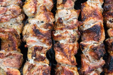 Domuz etinin bir şiş bir mangal üzerinde kızartma. Dönüm etin kömürlerin üzerine. İştah açıcı şiş kebap. Lezzetli Barbekü.