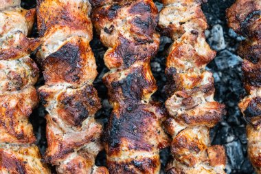 Domuz etinin bir şiş bir mangal üzerinde kızartma. Dönüm etin kömürlerin üzerine. İştah açıcı şiş kebap. Lezzetli Barbekü.