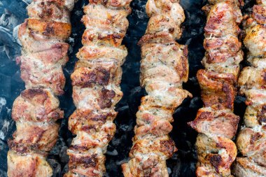 Domuz etinin bir şiş bir mangal üzerinde kızartma. Dönüm etin kömürlerin üzerine. İştah açıcı şiş kebap. Lezzetli Barbekü.