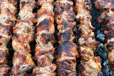 Domuz etinin bir şiş bir mangal üzerinde kızartma. Dönüm etin kömürlerin üzerine. İştah açıcı şiş kebap. Lezzetli Barbekü.