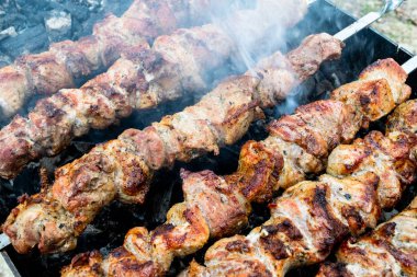 Domuz etinin bir şiş bir mangal üzerinde kızartma. Dönüm etin kömürlerin üzerine. İştah açıcı şiş kebap. Lezzetli Barbekü.