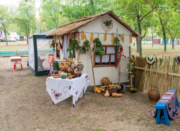 Herscheppen van het landelijke leven van de Kozakken. Een hut en een straat tafel met voedsel. — Stockfoto
