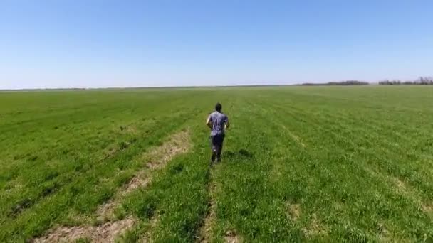 Ένας Άνθρωπος Που Τρέχει Μέσω Του Πεδίου Τζόκινγκ Στο Φρέσκο — Αρχείο Βίντεο