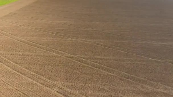 Volando sobre el campo arado cerca del pueblo . — Vídeos de Stock