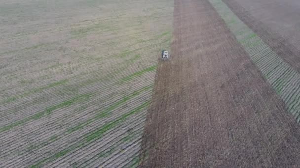Вид сверху на трактор, который вспахивает поле. дисков почвы. Обработка почвы после сбора урожая — стоковое видео