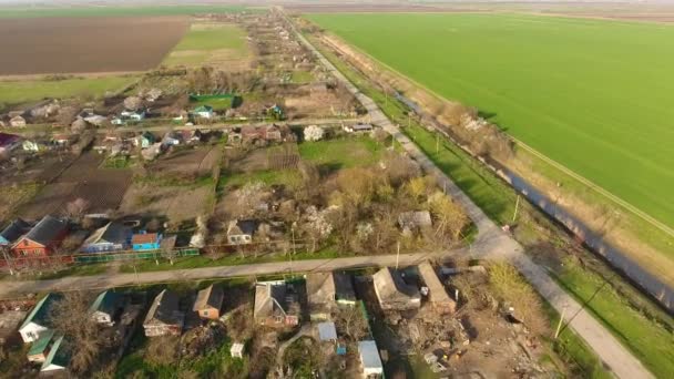 Blick von oben auf das Dorf. Man sieht die Dächer der Häuser und Gärten. Straße im Dorf. Dorf-Vogelperspektive — Stockvideo