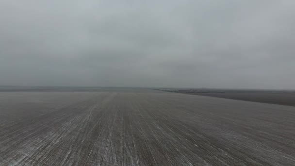 Draufsicht auf ein gepflügtes Feld im Winter. ein Weizenfeld im Schnee — Stockvideo