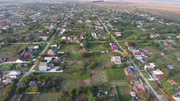 Bovenaanzicht van het dorp. Men kan zien de daken van de huizen en tuinen. Weg en water in het dorp. Dorp vogel-oog mening — Stockvideo