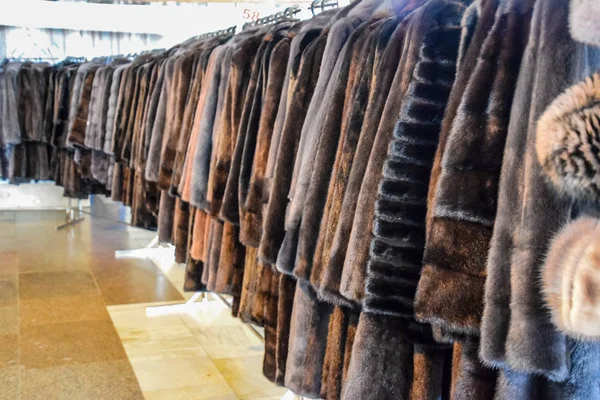 Fur coats on hangers. Fur store. fur coats in a row.