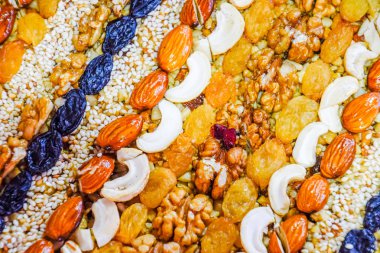 Kozinaki deli ve tohum ile kaplı. Badem, kaju fıstığı ve kuru üzüm.