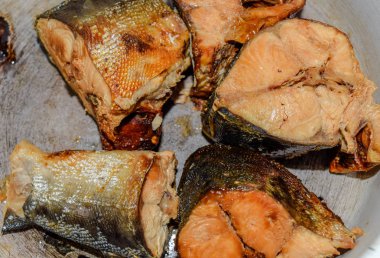 Biftek pembe somon, kavrulmuş. Emaye bir kadehte yalan. Pembe somon