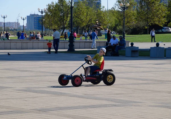 Kinderen rijden in het park op auto's met pedalen. Admiraal Serebryakov Square. Childrens recreatie. — Stockfoto