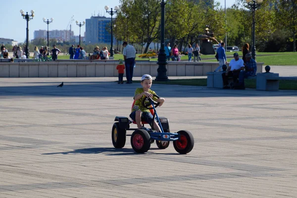 Kinder fahren im Park auf Autos mit Pedalen. Admiral Serebrjakow Platz. Freizeit für Kinder. — Stockfoto