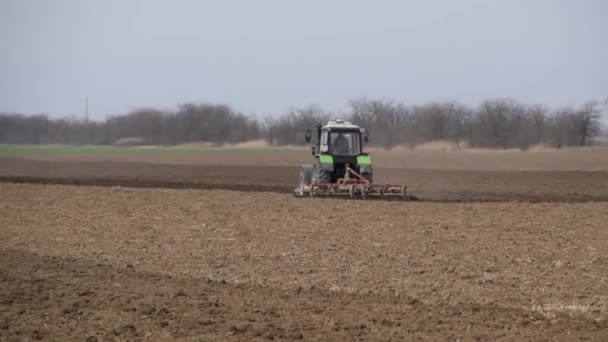 Lave e solte o solo no campo antes de semear. O trator arado um campo com um arado . — Vídeo de Stock