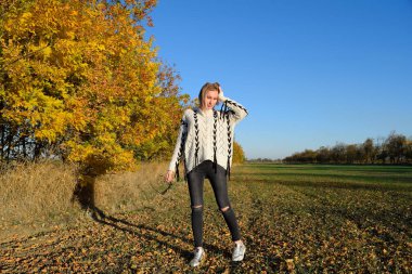 Kız sarı bir arka plan üzerinde sonbahar ağaçlarının yaprakları. Sonbahar fotoğraf oturumu.