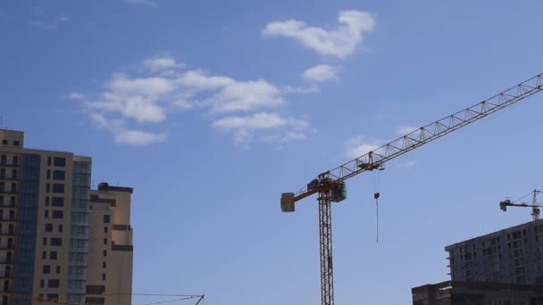 Turmbaukran gegen blauen Himmel und Sonne. Bau von Neubauten mit einem Kran. Turmkran. — Stockvideo