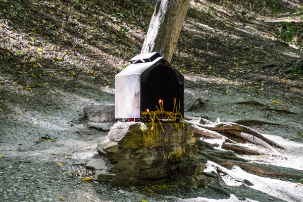 Православні свічки в лісі під деревом у коробці. Молитовний камінь біля дороги — стокове фото