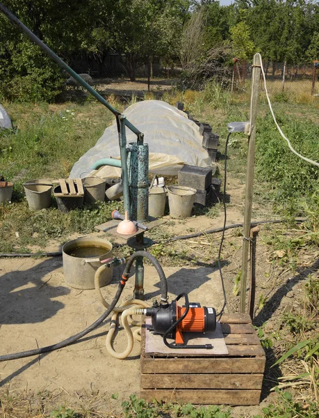 Irrigation system in the home garden. Well with manual and automatic pump. — Stock Photo, Image