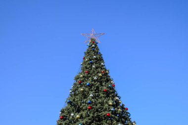 Süslemeleri yılbaşı ağacı. Tinsel ve oyuncaklar, topları ve diğer süslemeleri Noel Noel ayakta açık havada ağaç.
