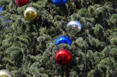 Süslemeleri yılbaşı ağacı. Tinsel ve oyuncaklar, topları ve diğer süslemeleri Noel Noel ayakta açık havada ağaç.