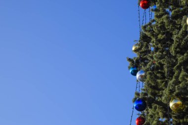 Süslemeleri yılbaşı ağacı. Tinsel ve oyuncaklar, topları ve diğer süslemeleri Noel Noel ayakta açık havada ağaç.