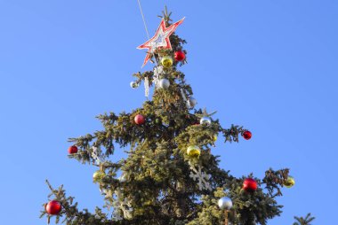 Süslemeleri yılbaşı ağacı. Tinsel ve oyuncaklar, topları ve diğer süslemeleri Noel Noel ayakta açık havada ağaç.
