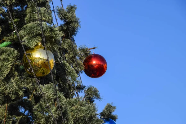 Süslemeleri yılbaşı ağacı. Tinsel ve oyuncaklar, topları ve diğer süslemeleri Noel Noel ayakta açık havada ağaç. — Stok fotoğraf