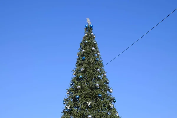 Süslemeleri yılbaşı ağacı. Tinsel ve oyuncaklar, topları ve diğer süslemeleri Noel Noel ayakta açık havada ağaç. — Stok fotoğraf