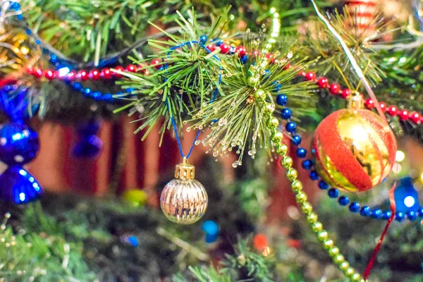 Decorações árvore de Ano Novo. Tinsel e brinquedos, bolas e outras decorações na árvore de Natal de pé ao ar livre . — Fotografia de Stock