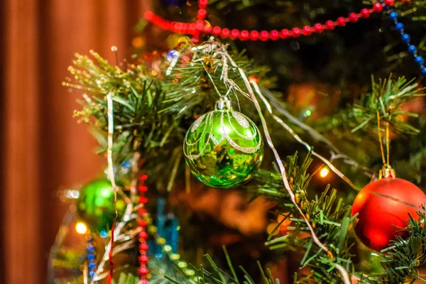 Decorações árvore de Ano Novo. Tinsel e brinquedos, bolas e outras decorações na árvore de Natal de pé ao ar livre . — Fotografia de Stock