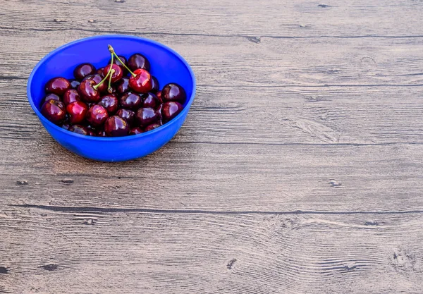 Beri ceri manis dengan latar belakang kayu di dalam gelas plastik. cherry merah manis matang — Stok Foto