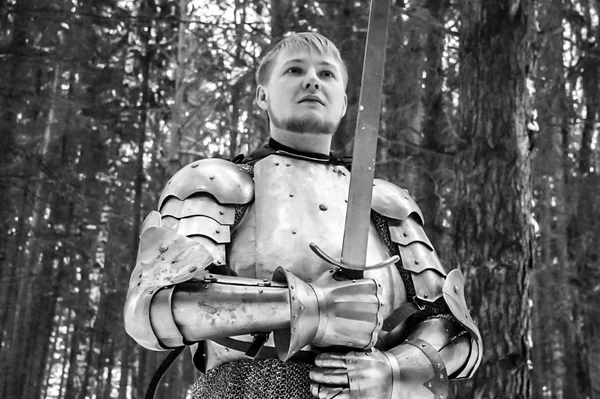 Chevalier en armure et avec une épée au milieu d'une forêt d'hiver. Uniforme militaire vintage — Photo