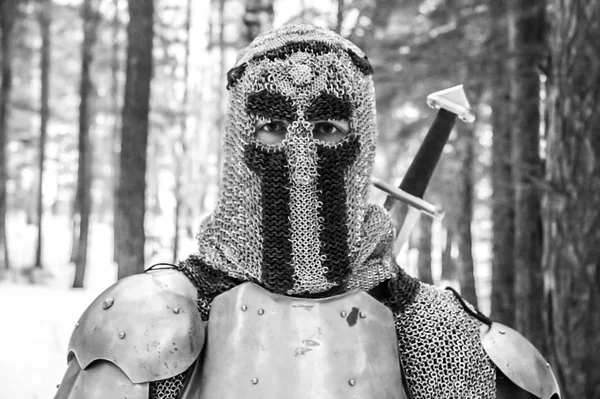 Chevalier en armure et avec une épée au milieu d'une forêt d'hiver. Uniforme militaire vintage — Photo