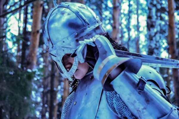 Ritter in Rüstung und mit Schwert inmitten eines Winterwaldes. Militärische Uniform — Stockfoto