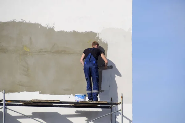 Stukadoors bouwers gepleisterd muur in een bedrijfsgebouw. Wor Stockfoto