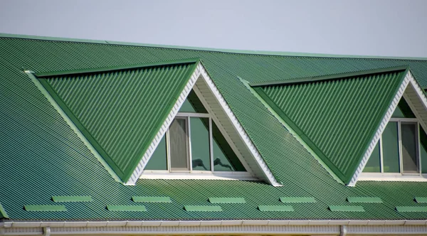 有塑料窗户和绿色瓦楞纸屋顶的房子 屋面为金属表面波浪形 房顶上有塑料窗 波纹金属表面和塑料窗户绿色屋顶 — 图库照片