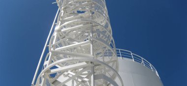 Tank ile su ve bir merdiven. Birincil Petrol arıtma için donatım.