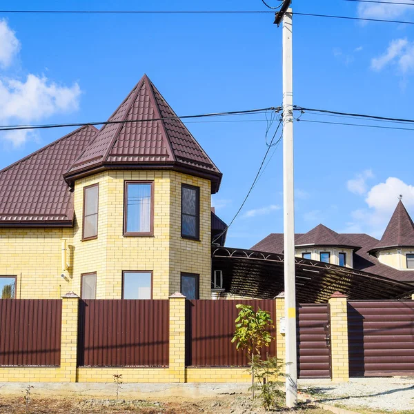 れんが造りの家の屋根の上の装飾的な金属 段ボールの金属製のフェンス — ストック写真